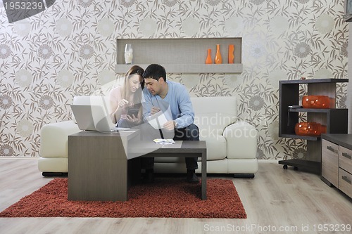 Image of young couple working on laptop at home