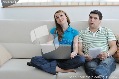 Image of young couple working on laptop at home