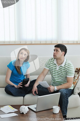 Image of young couple working on laptop at home