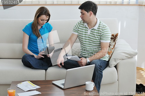 Image of young couple working on laptop at home