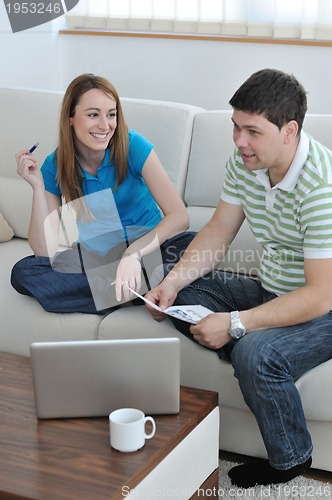 Image of young couple working on laptop at home