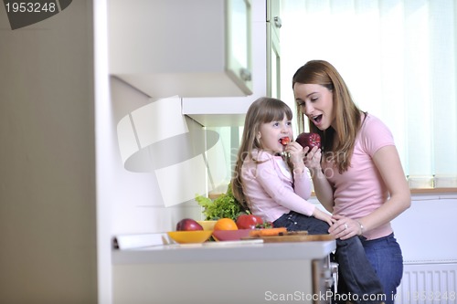 Image of happy daughter and mom in kitchen
