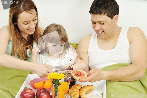 Image of happy young family eat breakfast in bed