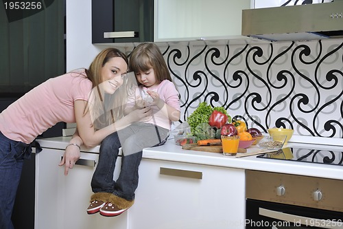 Image of happy daughter and mom in kitchen