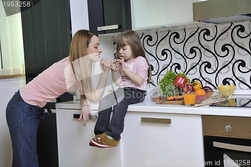 Image of happy daughter and mom in kitchen