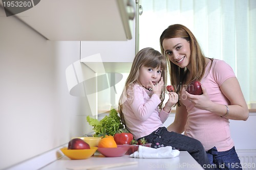 Image of happy daughter and mom in kitchen