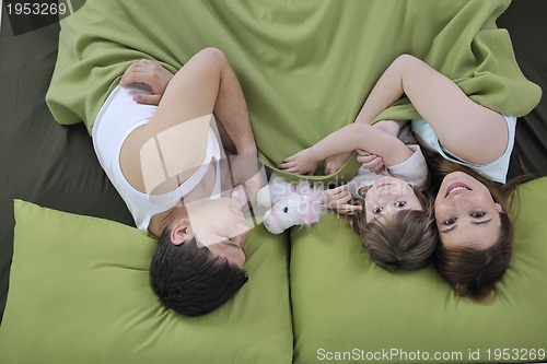 Image of happy family relaxing in bed