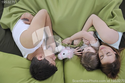 Image of happy family relaxing in bed