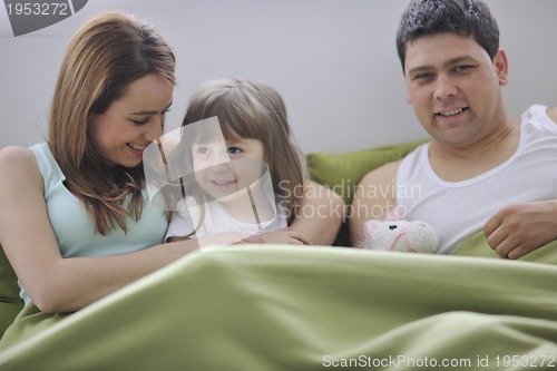 Image of happy family relaxing in bed