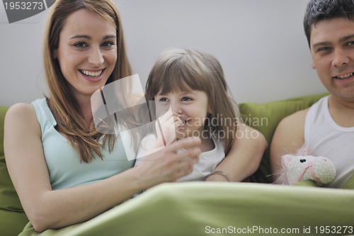 Image of happy family relaxing in bed