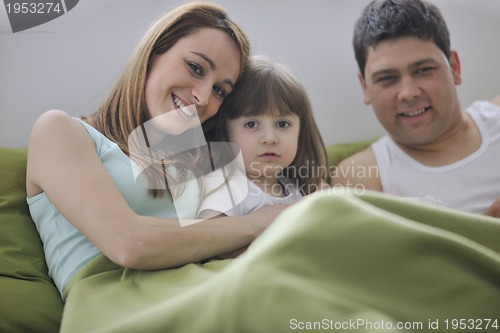 Image of happy family relaxing in bed