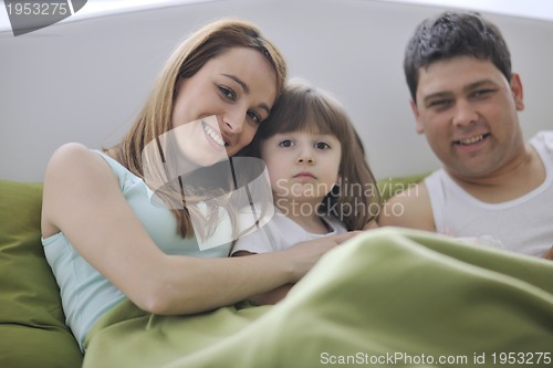 Image of happy family relaxing in bed