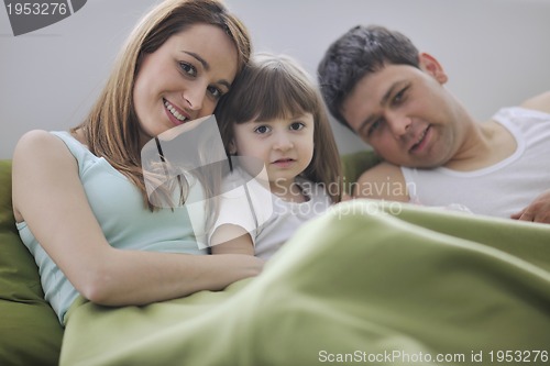 Image of happy family relaxing in bed