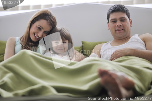Image of happy family relaxing in bed