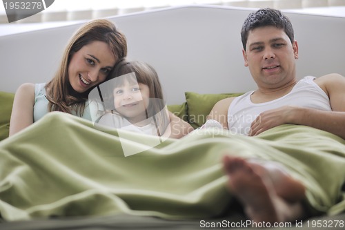Image of happy family relaxing in bed