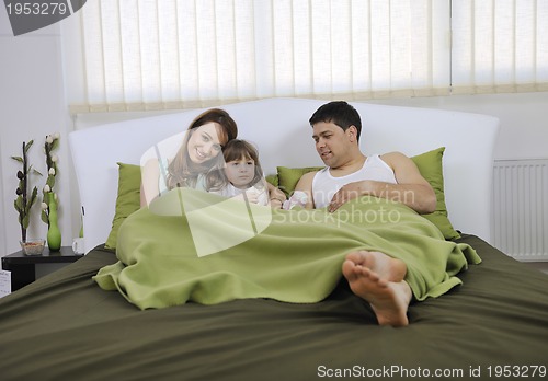 Image of happy family relaxing in bed