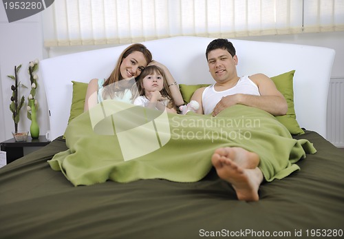 Image of happy family relaxing in bed