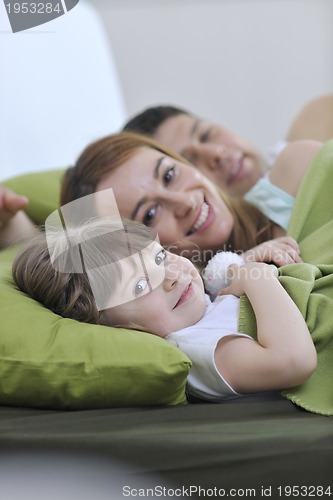 Image of happy family relaxing in bed