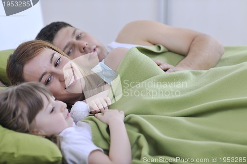 Image of happy family relaxing in bed