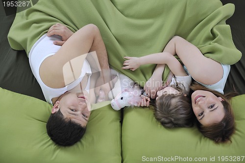 Image of happy family relaxing in bed