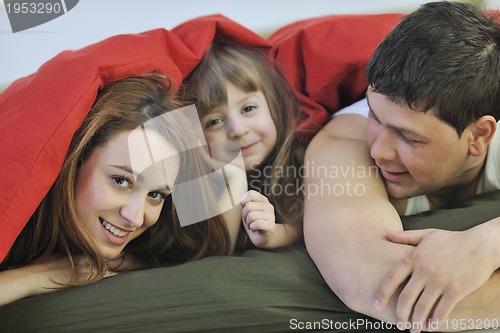 Image of happy family relaxing in bed