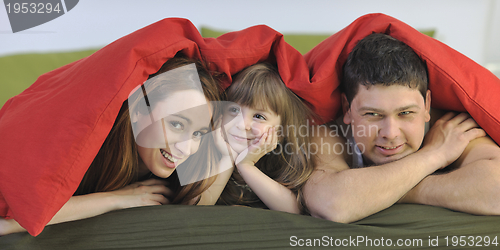 Image of happy family relaxing in bed