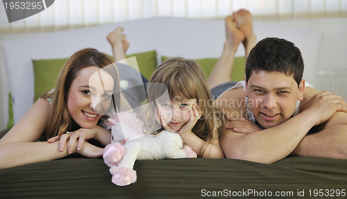 Image of happy family relaxing in bed