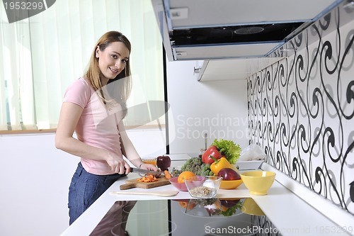 Image of happy young  woman in kitchen