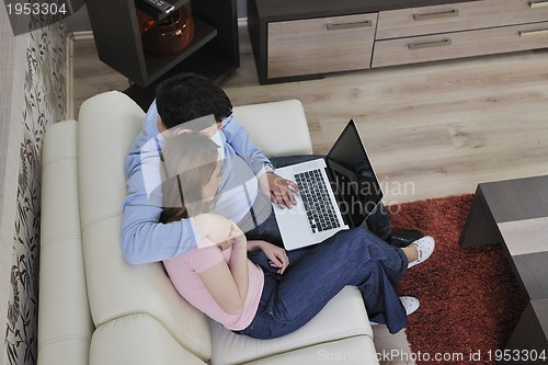 Image of young couple working on laptop at home