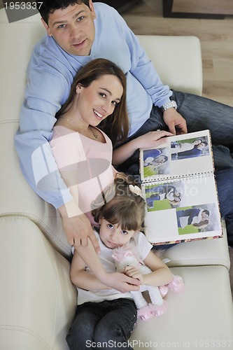 Image of happy family looking photos at home