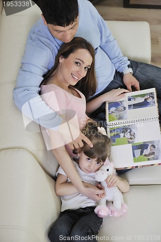 Image of happy family looking photos at home