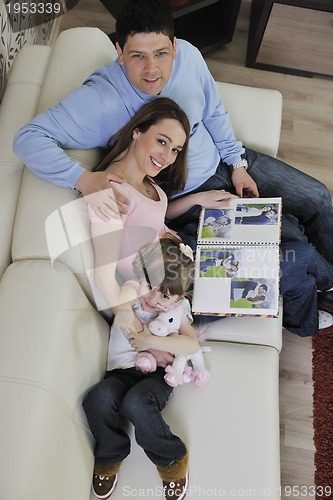 Image of happy family looking photos at home