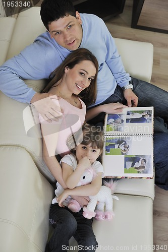 Image of happy family looking photos at home