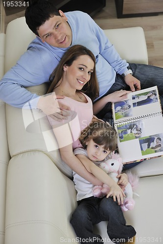 Image of happy family looking photos at home