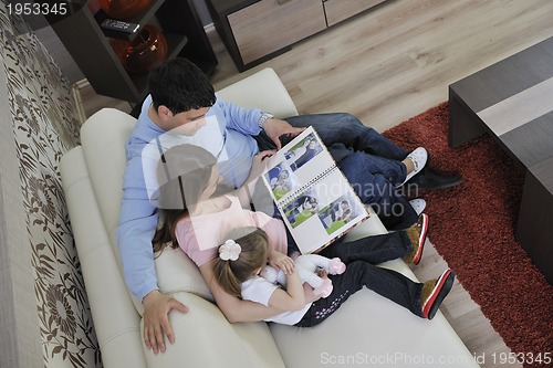 Image of happy family looking photos at home