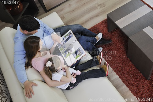 Image of happy family looking photos at home