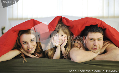 Image of happy family relaxing in bed