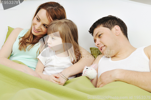 Image of happy family relaxing in bed
