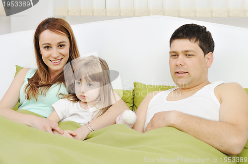 Image of happy family relaxing in bed