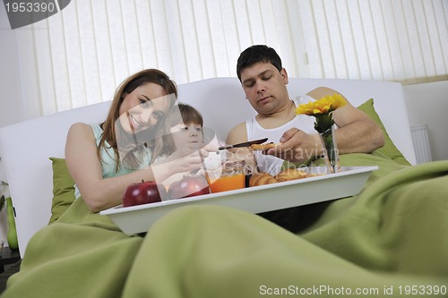 Image of happy young family eat breakfast in bed