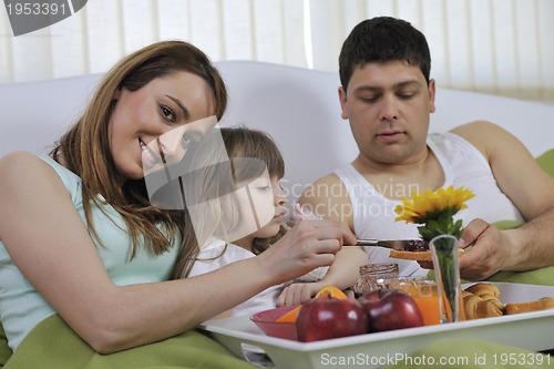 Image of happy young family eat breakfast in bed