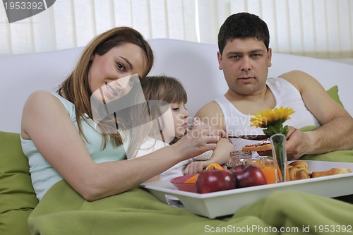 Image of happy young family eat breakfast in bed