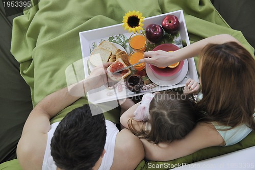 Image of happy young family eat breakfast in bed