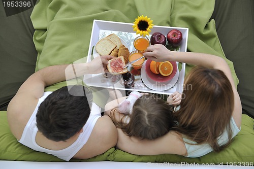 Image of happy young family eat breakfast in bed