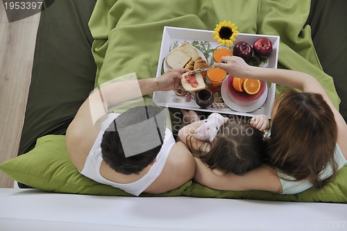 Image of happy young family eat breakfast in bed