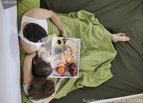 Image of happy young family eat breakfast in bed