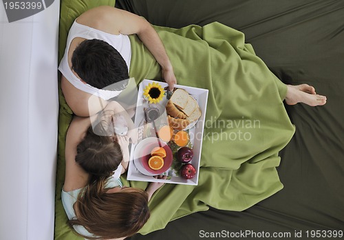 Image of happy young family eat breakfast in bed