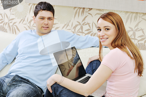 Image of young couple working on laptop at home