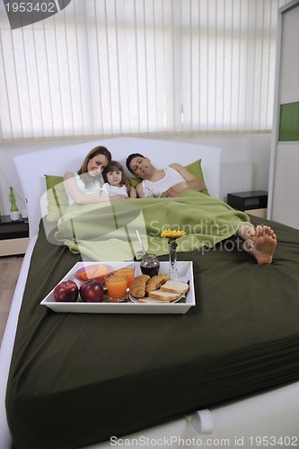 Image of happy young family eat breakfast in bed