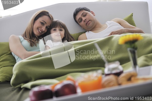 Image of happy young family eat breakfast in bed